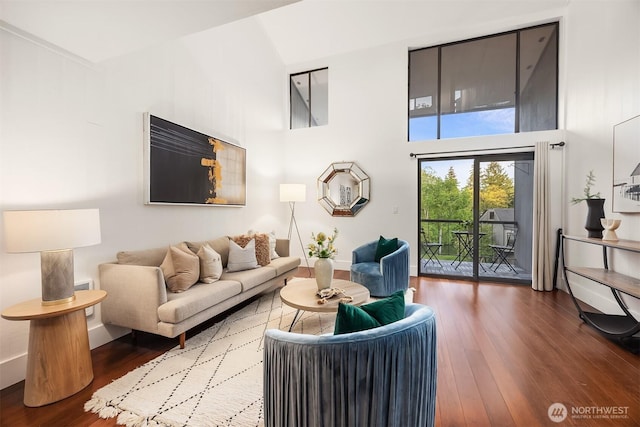 living room with wood finished floors, high vaulted ceiling, and baseboards