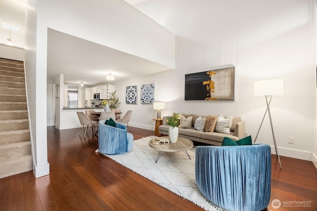 living area with stairway, dark wood-style flooring, and baseboards
