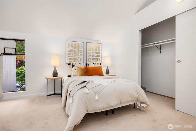 carpeted bedroom with baseboards, a closet, and vaulted ceiling