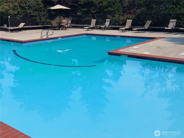 community pool featuring fence and a patio