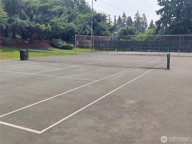 view of tennis court featuring fence and community basketball court