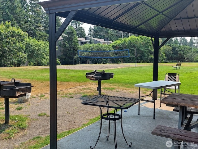 surrounding community with volleyball court, a yard, and a patio