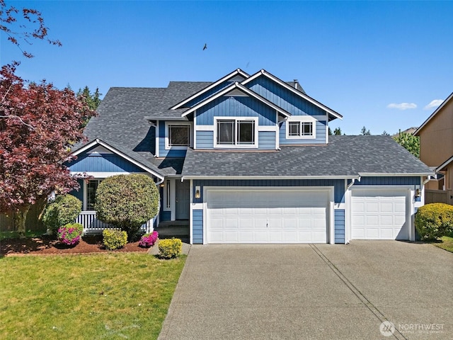 view of front of house featuring a garage, roof with shingles, a front yard, and concrete driveway