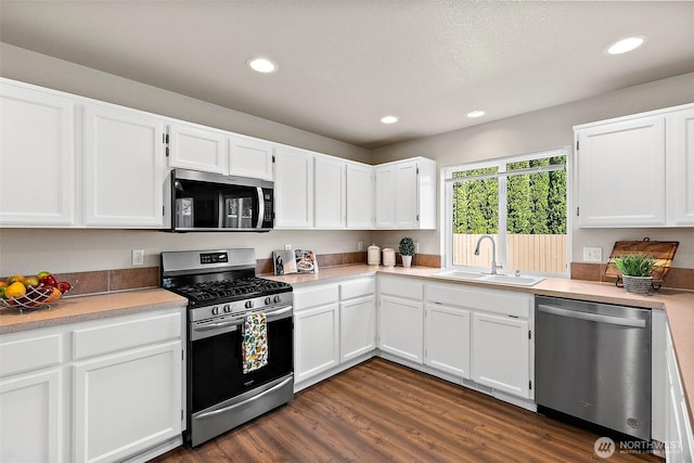 kitchen with recessed lighting, a sink, appliances with stainless steel finishes, and white cabinets