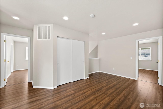 interior space featuring recessed lighting, baseboards, dark wood-style floors, and visible vents