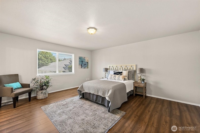 bedroom with baseboards, a textured ceiling, and wood finished floors