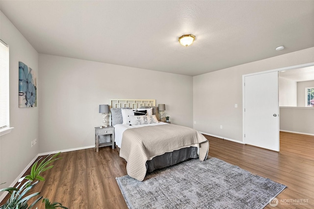 bedroom with baseboards and wood finished floors