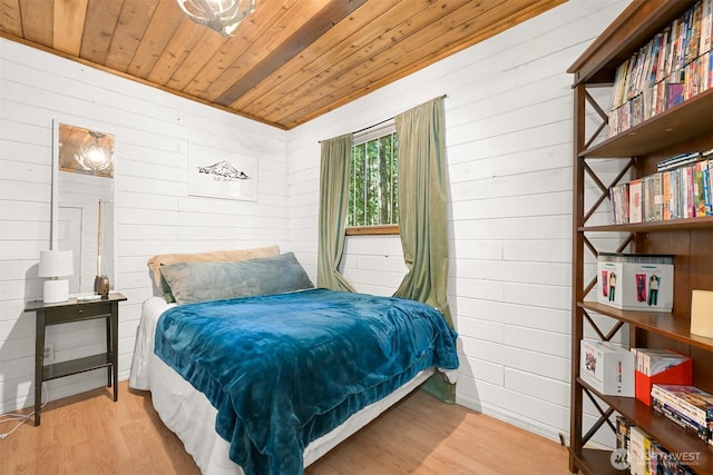 bedroom with wooden ceiling, wood walls, and wood finished floors
