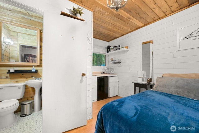 bedroom with fridge, a sink, wooden walls, and wooden ceiling