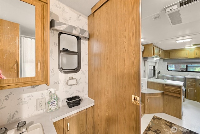 kitchen with a sink, light countertops, and visible vents