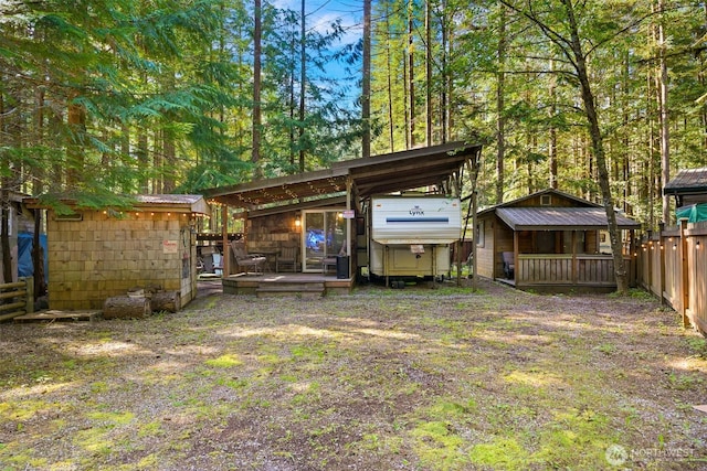 view of yard with fence, a storage unit, an outbuilding, and a deck