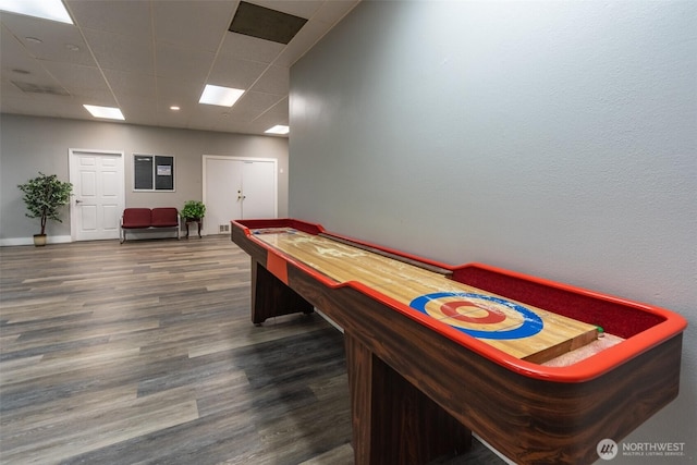playroom featuring baseboards, a drop ceiling, and wood finished floors