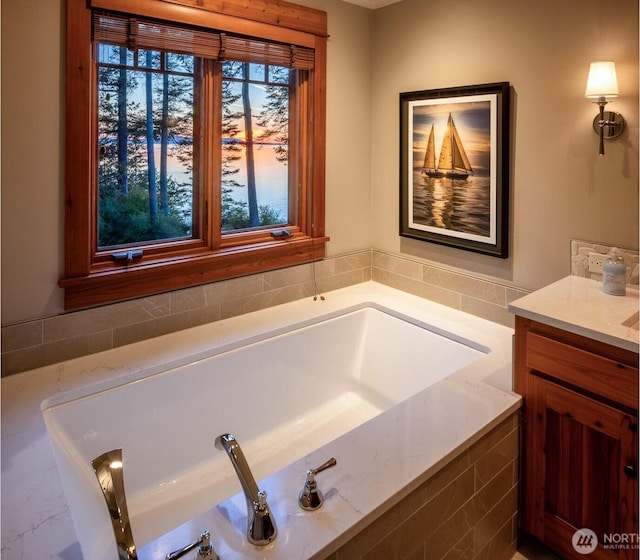 full bath featuring a garden tub and vanity