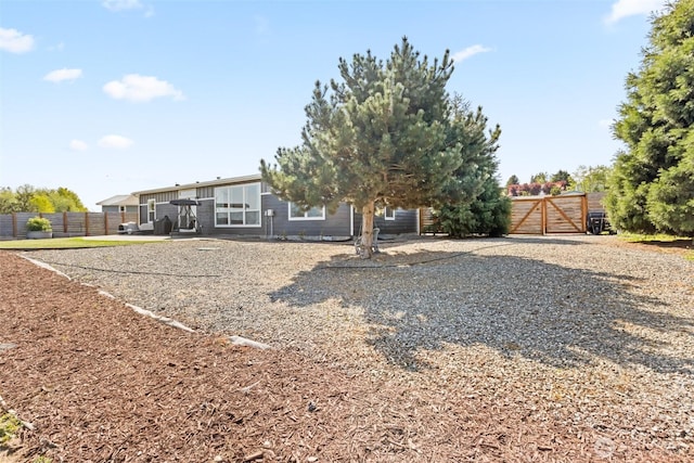 back of property with a gate and fence