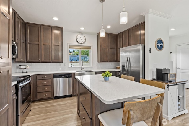 kitchen featuring decorative backsplash, dark brown cabinets, light wood-type flooring, a sink, and stainless steel appliances