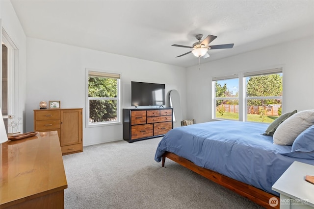 bedroom with baseboards, a ceiling fan, and light colored carpet