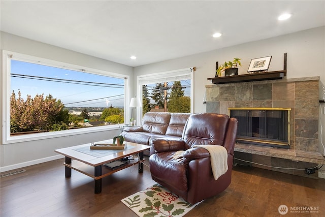 living room with a tiled fireplace, recessed lighting, baseboards, wood finished floors, and visible vents