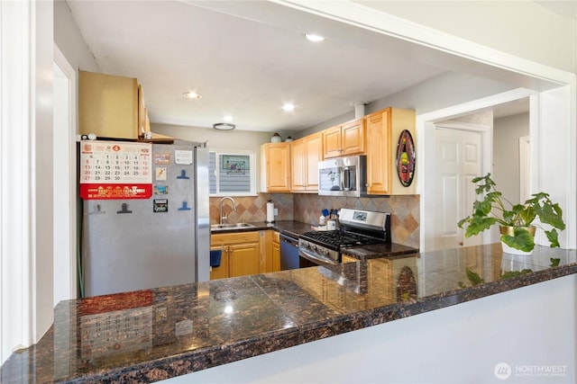kitchen with a sink, light brown cabinets, tile counters, stainless steel appliances, and tasteful backsplash