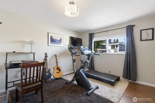 workout area featuring baseboards and wood finished floors