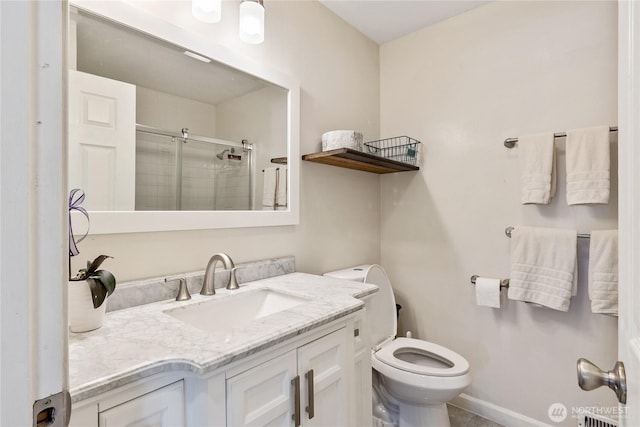 bathroom featuring vanity, baseboards, a stall shower, and toilet