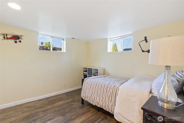 bedroom featuring baseboards, multiple windows, wood finished floors, and visible vents