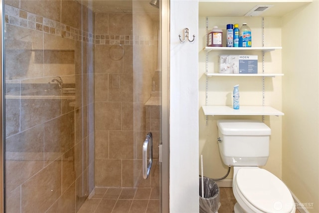 bathroom featuring toilet and a shower stall