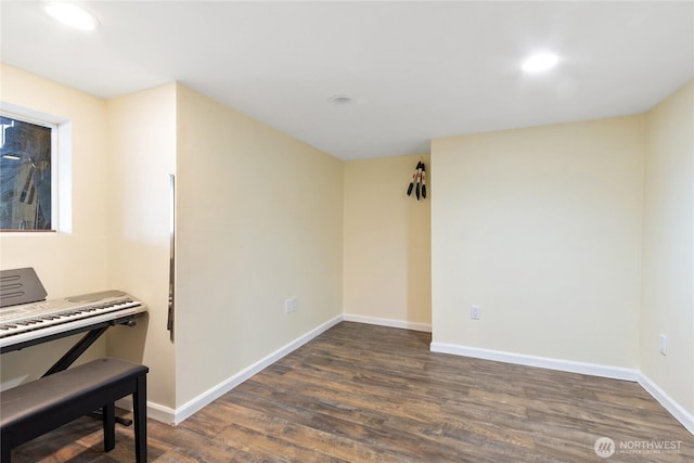 empty room featuring recessed lighting, baseboards, and dark wood-type flooring