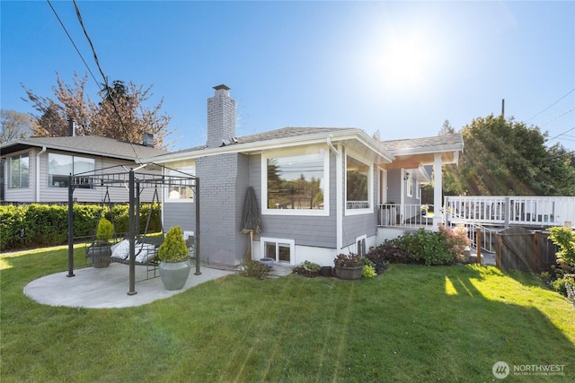 rear view of property with a lawn, a chimney, and a gazebo