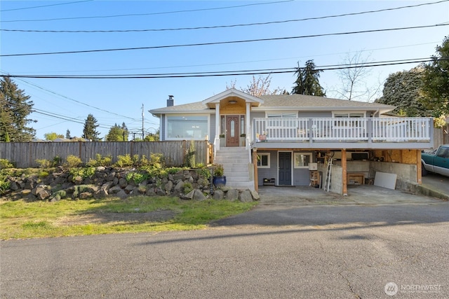 view of front facade with fence, a deck, a chimney, stairs, and driveway