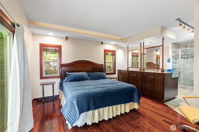 bedroom with recessed lighting, ensuite bath, rail lighting, and wood finished floors