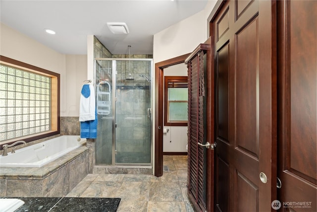 full bathroom featuring a shower stall and a garden tub