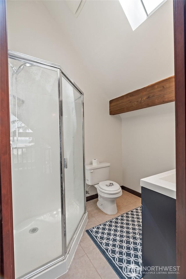bathroom featuring vaulted ceiling with skylight, tile patterned floors, a stall shower, and toilet