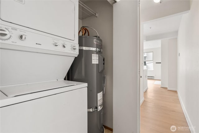 769 Hayes St Unit 405, Seattle, WA 98109 - laundry room featuring stacked washer / drying machine, secured water heater, light wood-type flooring, and a baseboard heating unit