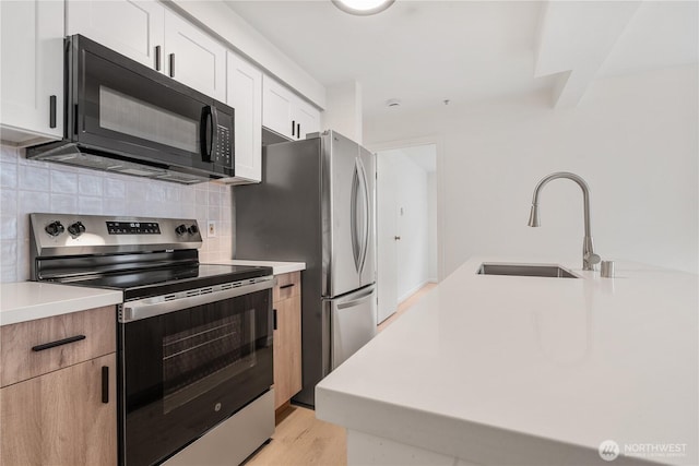 769 Hayes St Unit 405, Seattle, WA 98109 - kitchen featuring appliances with stainless steel finishes, tasteful backsplash, light countertops, and light wood-style flooring