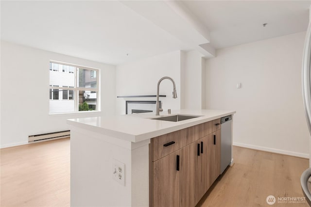 769 Hayes St Unit 405, Seattle, WA 98109 - kitchen with modern cabinets, light wood-style floors, stainless steel dishwasher, a fireplace, and an island with sink