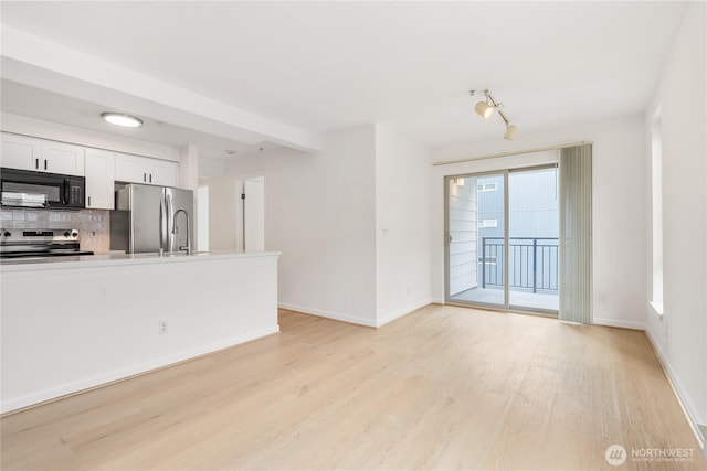 769 Hayes St Unit 405, Seattle, WA 98109 - unfurnished living room featuring light wood-type flooring and baseboards