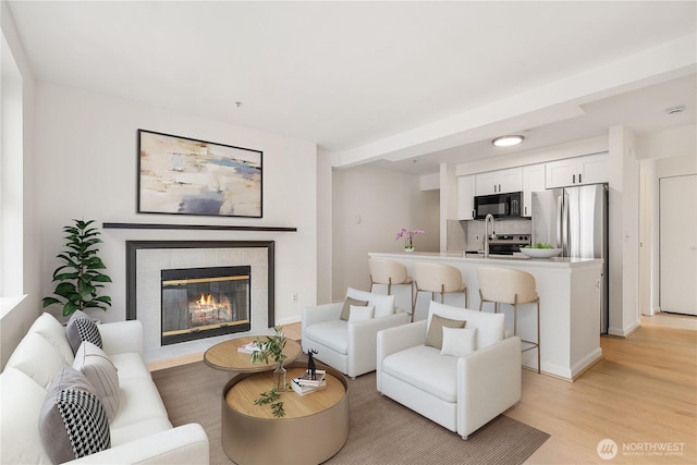 769 Hayes St Unit 405, Seattle, WA 98109 - living area featuring light wood finished floors and a tile fireplace