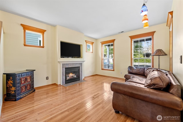 7827 Ingram Ln SE, Snoqualmie, WA 98065 - living area featuring baseboards, light wood-style flooring, and a tile fireplace