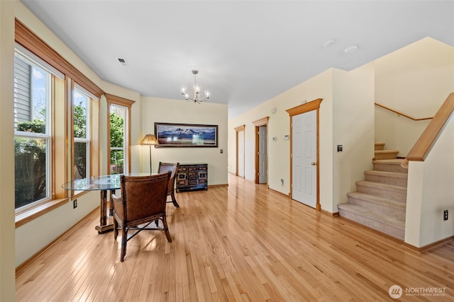 7827 Ingram Ln SE, Snoqualmie, WA 98065 - dining space featuring baseboards, a notable chandelier, light wood-style flooring, and stairway