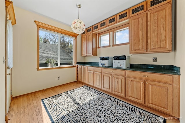 7827 Ingram Ln SE, Snoqualmie, WA 98065 - kitchen featuring baseboards, dark countertops, glass insert cabinets, and light wood-style flooring