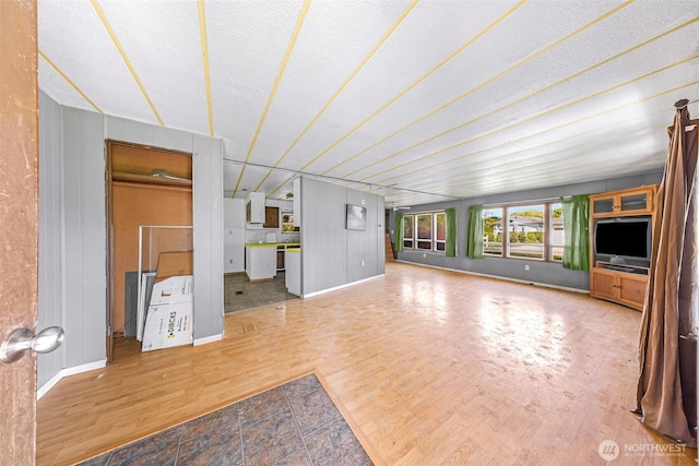 unfurnished living room with baseboards and wood finished floors