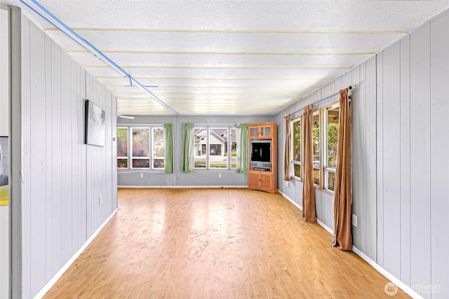 unfurnished living room featuring baseboards and light wood finished floors