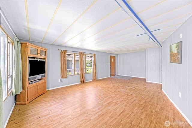 unfurnished living room featuring baseboards and light wood-type flooring
