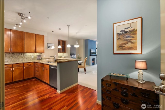 150 102nd Ave SE Unit 213, Bellevue, WA 98004 - kitchen featuring brown cabinetry, dishwasher, a sink, a peninsula, and dark wood-style floors