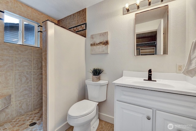 full bathroom featuring a walk in shower, vanity, baseboards, and toilet
