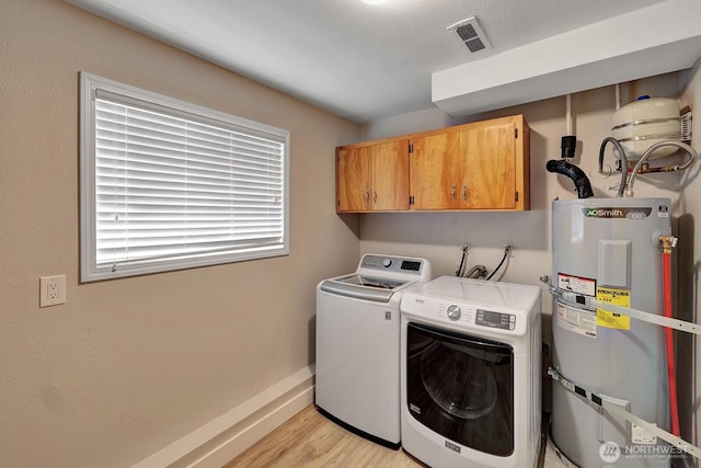 laundry room featuring cabinet space, washer and dryer, light wood-style flooring, water heater, and visible vents