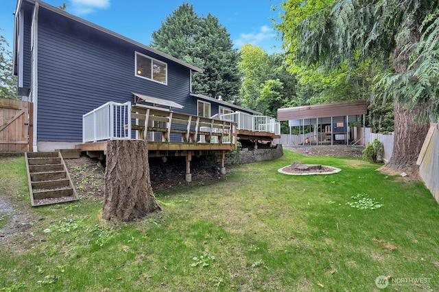 back of house with stairs, a fenced backyard, a yard, and a deck