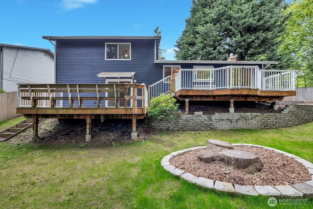 rear view of house featuring a wooden deck and a yard