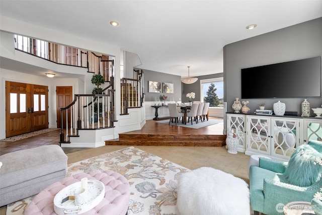 living area featuring carpet flooring, recessed lighting, and stairway