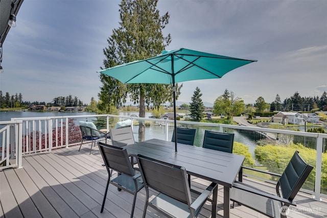 wooden terrace featuring outdoor dining space and a water view